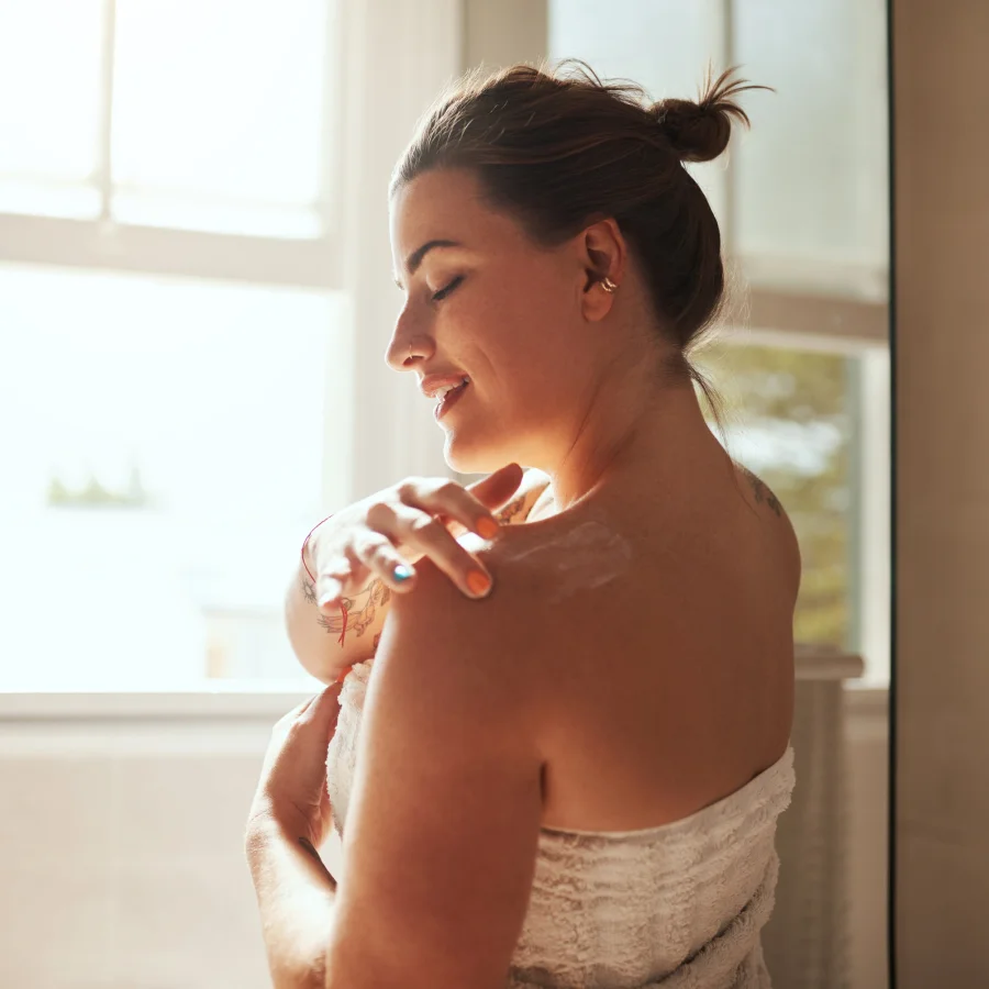 A woman wrapped in a towel raises her arm, showcasing a relaxed and casual pose.
