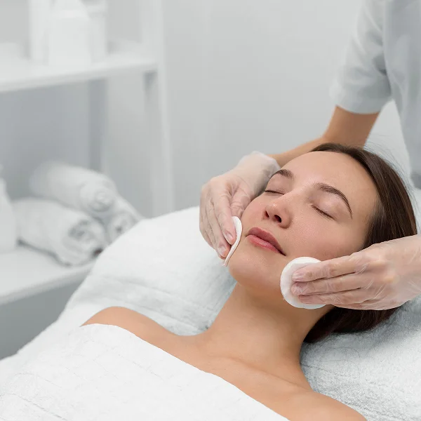 A woman receiving a facial treatment at a spa, focusing on skin care and relaxation.